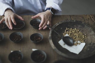 Barista 'nın elleri kahve çekirdeklerini tartıyor.