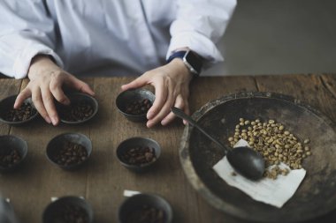 Barista 'nın elleri kahve çekirdeklerini tartıyor.