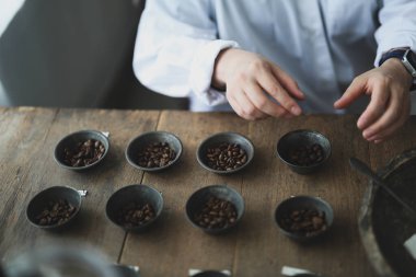 Barista 'nın elleri kahve çekirdeklerini tartıyor.