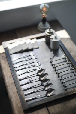 Antika kaşıklar ve çatallar dizilmiş.