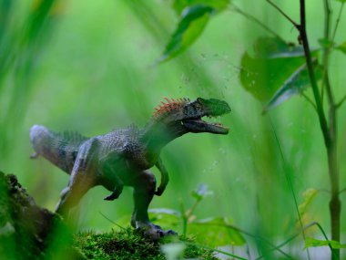 Tyrannosaurus figürü ve yeşil orman