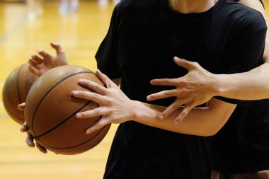 İnsanlar spor salonunda basketbol oynuyor.