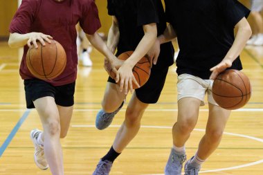 İnsanlar spor salonunda basketbol oynuyor.