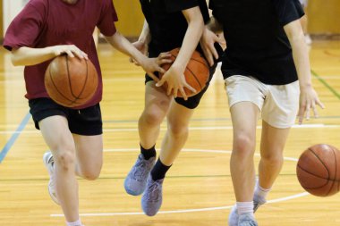 İnsanlar spor salonunda basketbol oynuyor.
