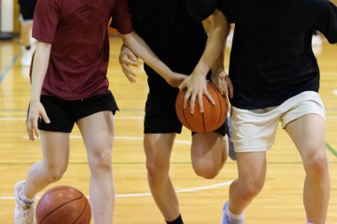 İnsanlar spor salonunda basketbol oynuyor.