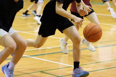 İnsanlar spor salonunda basketbol oynuyor.