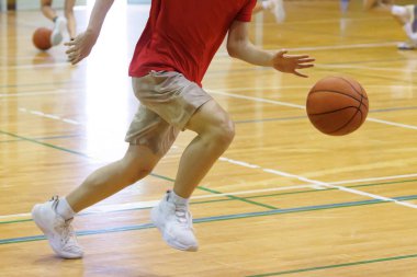 İnsanlar spor salonunda basketbol oynuyor.