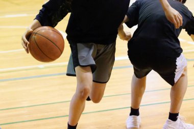 İnsanlar spor salonunda basketbol oynuyor.