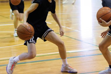 İnsanlar spor salonunda basketbol oynuyor.