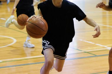 İnsanlar spor salonunda basketbol oynuyor.