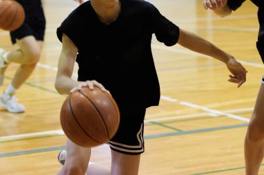 İnsanlar spor salonunda basketbol oynuyor.