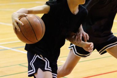 İnsanlar spor salonunda basketbol oynuyor.