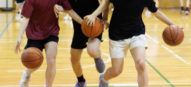 İnsanlar spor salonunda basketbol oynuyor.