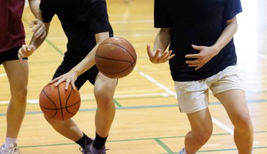 İnsanlar spor salonunda basketbol oynuyor.
