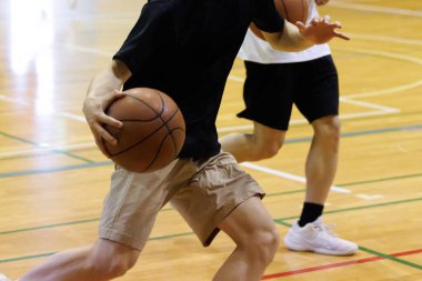 İnsanlar spor salonunda basketbol oynuyor.