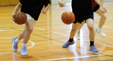 İnsanlar spor salonunda basketbol oynuyor.