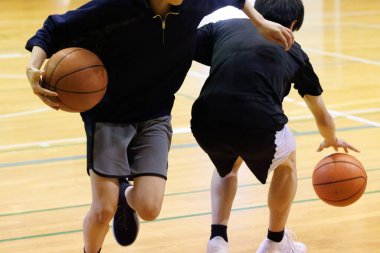 İnsanlar spor salonunda basketbol oynuyor.