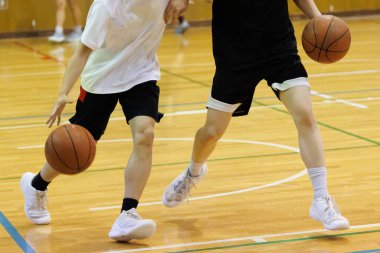 İnsanlar spor salonunda basketbol oynuyor.