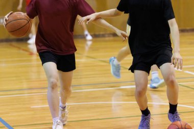 İnsanlar spor salonunda basketbol oynuyor.
