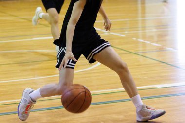 İnsanlar spor salonunda basketbol oynuyor.