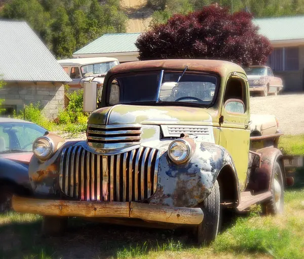 old car with a rusty car in the background.