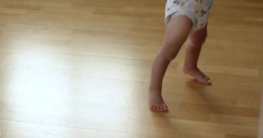Bebek ahşap zeminde ilk adımı atar, çocuk yürümeyi öğrenir, buzdolabını açar. Mutlu aile kavramı