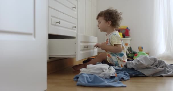 Однорічний Хлопчик Викидає Одяг Шафи Безладну Спальню Грає Веселиться Приміщенні — стокове відео
