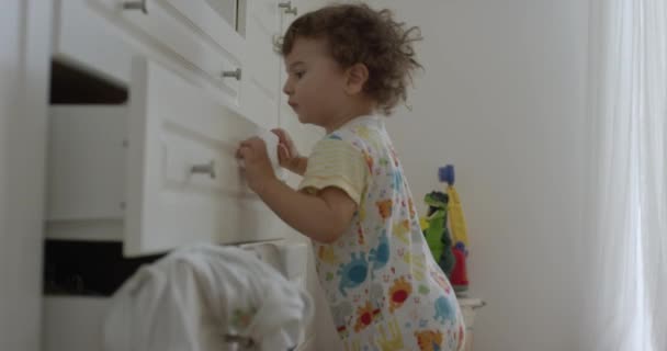 一岁的男婴把衣服从衣橱 凌乱的卧室 玩耍和在室内玩乐的地方扔了出来 视角也很低 — 图库视频影像