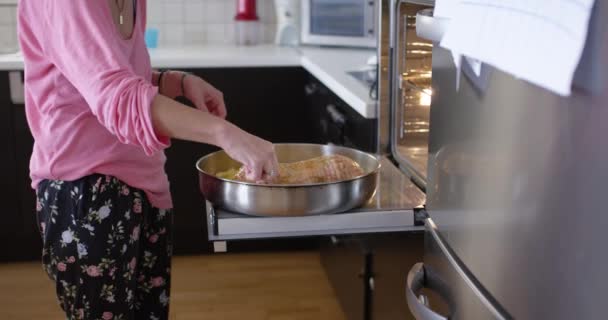 Mujer Preparando Una Comida Horno Mientras Sostiene Bebé Cocina Del — Vídeos de Stock