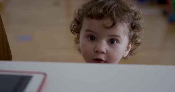 デジタルタブレットを使用しながら兄がおもちゃで遊んでいる赤ちゃんの少年 — ストック動画