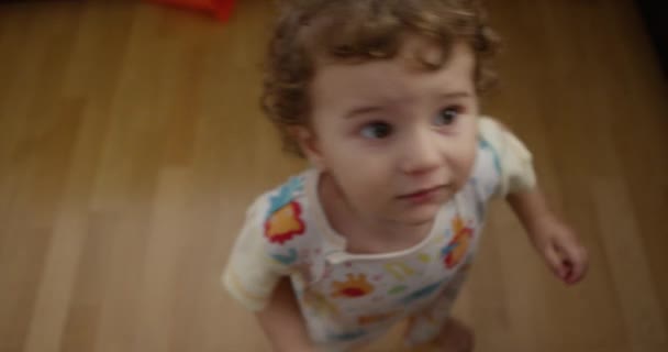 Niño Con Pelo Rizado Mira Biberón Ofrecido Por Una Mano — Vídeo de stock