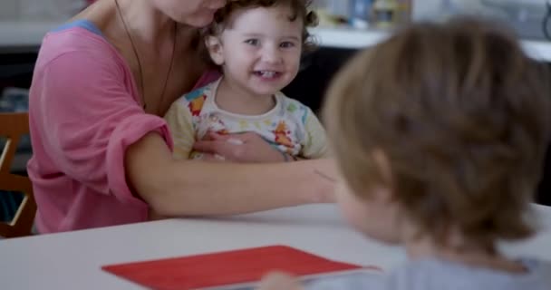 어머니가 그녀의 아기를 먹이는 소년은 디지털 태블릿과 테이블에 앉아있는 이야기 — 비디오