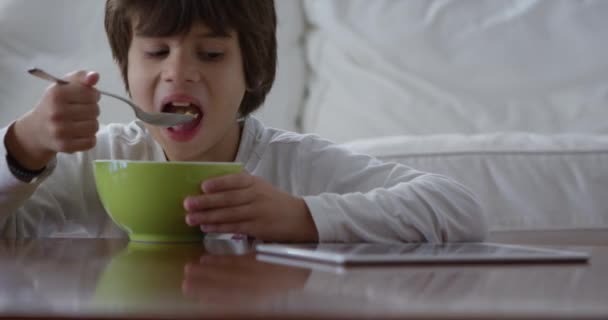 朝食を食べながらデジタルタブレットを使った3歳の少年 — ストック動画