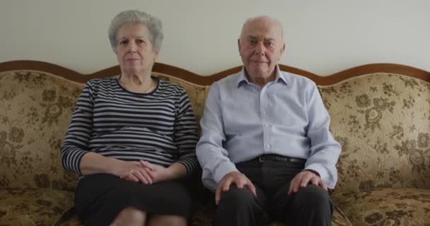 一位老年男女肩并肩地坐着 表现出镇定 伴侣和经验的表情 — 图库视频影像
