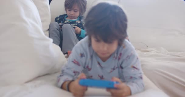 Çocuk Beyaz Bir Kanepede Yatarken Bilgisayarı Üzerine Odaklanmış — Stok video