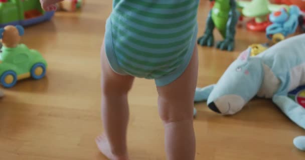 赤ちゃんが第一歩を踏み出す 母親は子供を抱きかかえて支え 家で歩くことを教えます 子供の人生の最初の年 高品質4K映像 — ストック動画