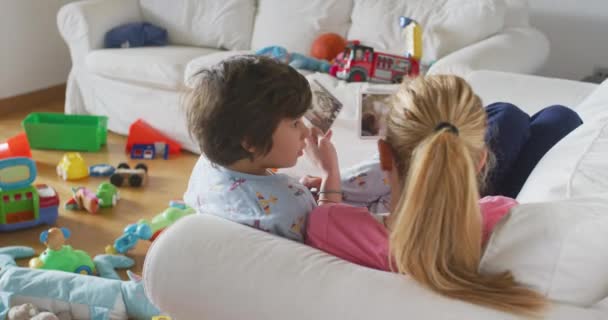Ung Mor Med Sine Børn Liggende Sofaen Stuen Ser Trykte – Stock-video