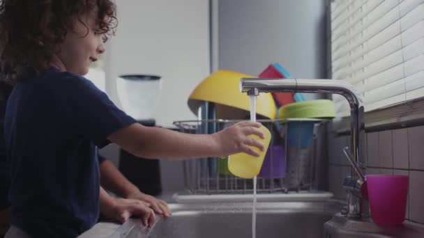Młode Dziecko Bawiące Się Wodą Zlewie Nowoczesnej Kuchni Wypełnia Plastikowy — Wideo stockowe