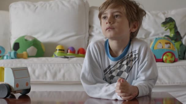 Zamyšlený Chlapec Sedí Hračkami Kolem Sebe Dívá Dálky — Stock video
