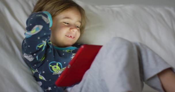 Uma Criança Concentra Intensamente Tablet Digital Deitado Sofá Brilho Suave — Vídeo de Stock