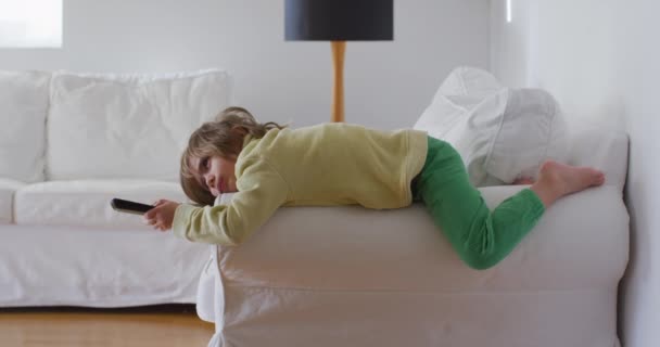 Menino Está Deitado Sofá Segurando Controle Remoto Mão Mudando Canal — Vídeo de Stock