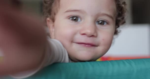 Uma Criança Curiosa Com Cabelos Ondulados Espreita Sobre Borda Playpen — Vídeo de Stock