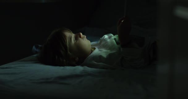 Pod Měkkou Září Obrazovky Leží Malé Dítě Posteli Uchvácené Digitálním — Stock video