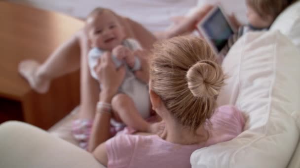 Uma Mãe Senta Confortavelmente Sofá Branco Engajando Seu Bebê Que — Vídeo de Stock