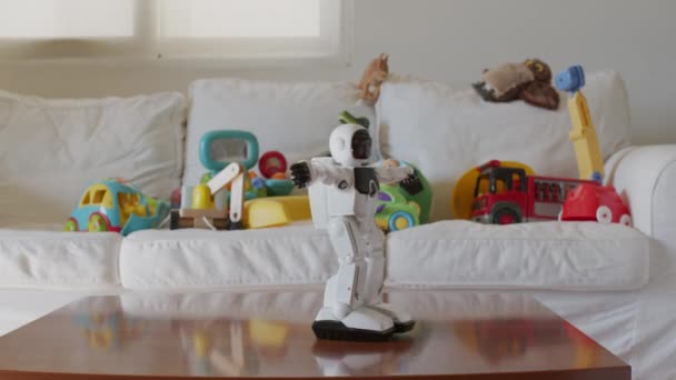 ロボットのおもちゃは 散らばったおもちゃでいっぱいのモダンなリビングルームの中心に明るく 自然光は居心地の良い設定を明るくします — ストック動画