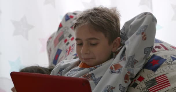 Chico Descansa Cómodamente Intensamente Enfocado Tableta Digital Colores Brillantes — Vídeo de stock