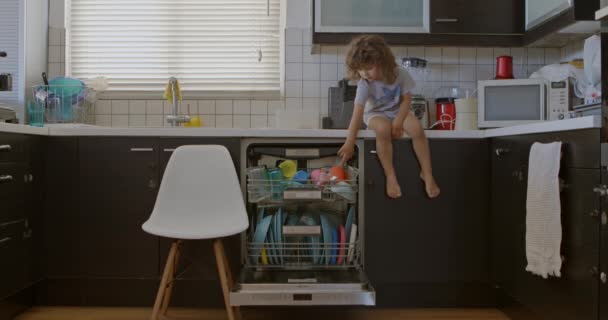 Niño Con Pelo Rizado Sienta Mostrador Cocina Con Las Piernas — Vídeo de stock