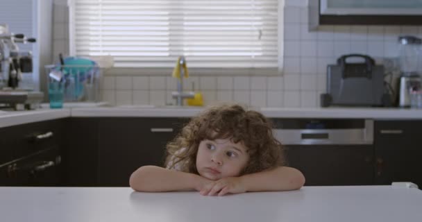 Curly Haired Boy Rests His Chin His Hands Kitchen Counter — Stock Video