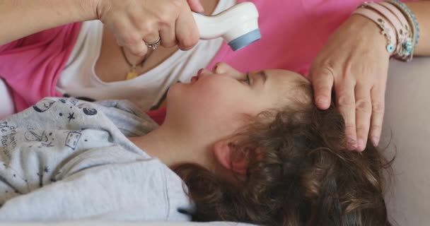 Enfant Allonge Tandis Une Mère Inquiète Utilise Doucement Thermomètre Frontal — Video