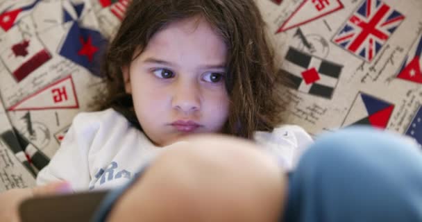 Bir Çocuk Rahatça Uzanır Dikkatle Renkli Dijital Tabletine Odaklanır — Stok video